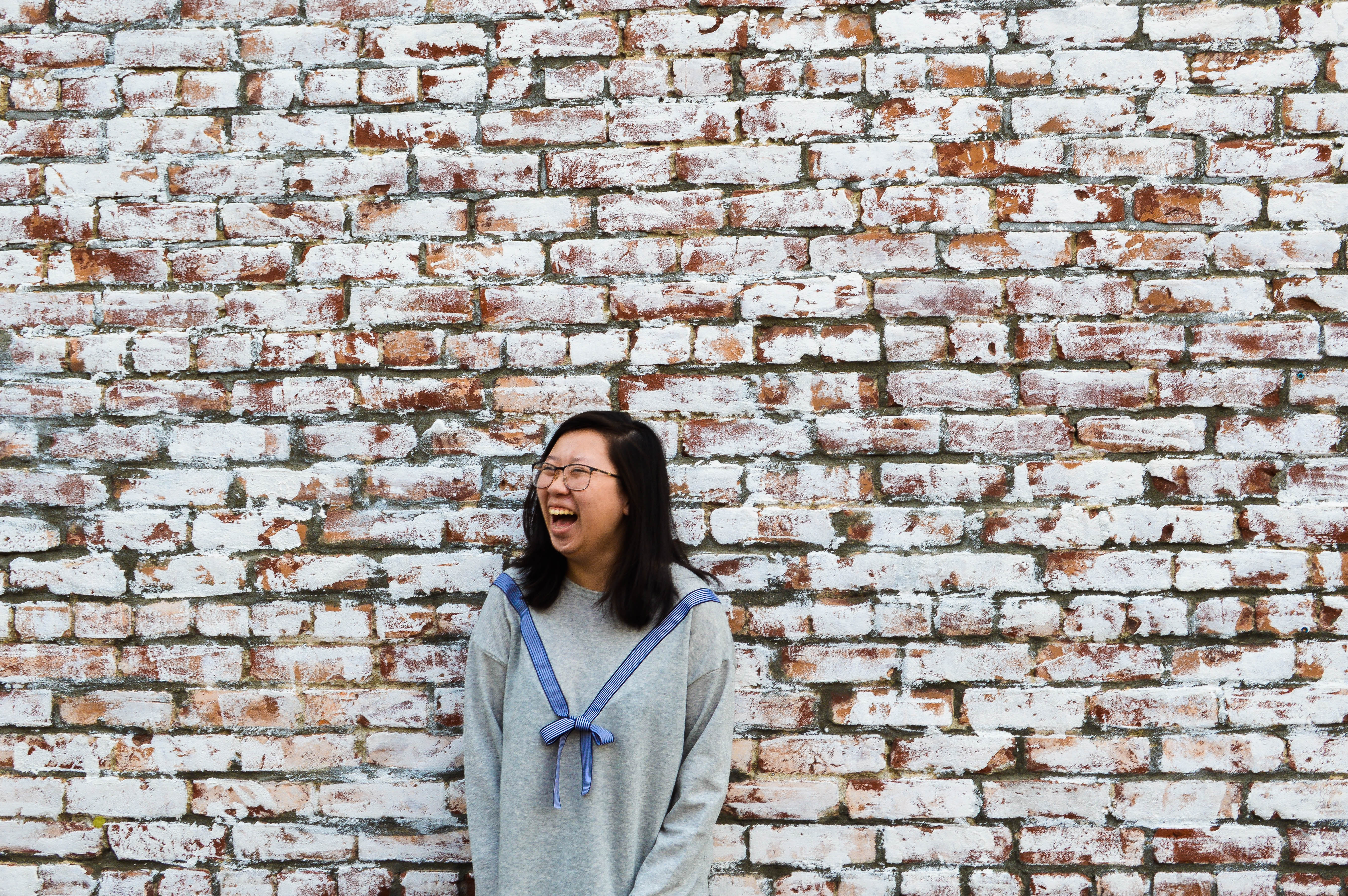 Girl in front of brick wall